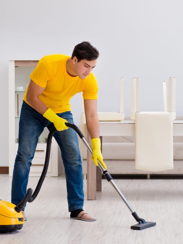 Man husband cleaning the house helping his wife